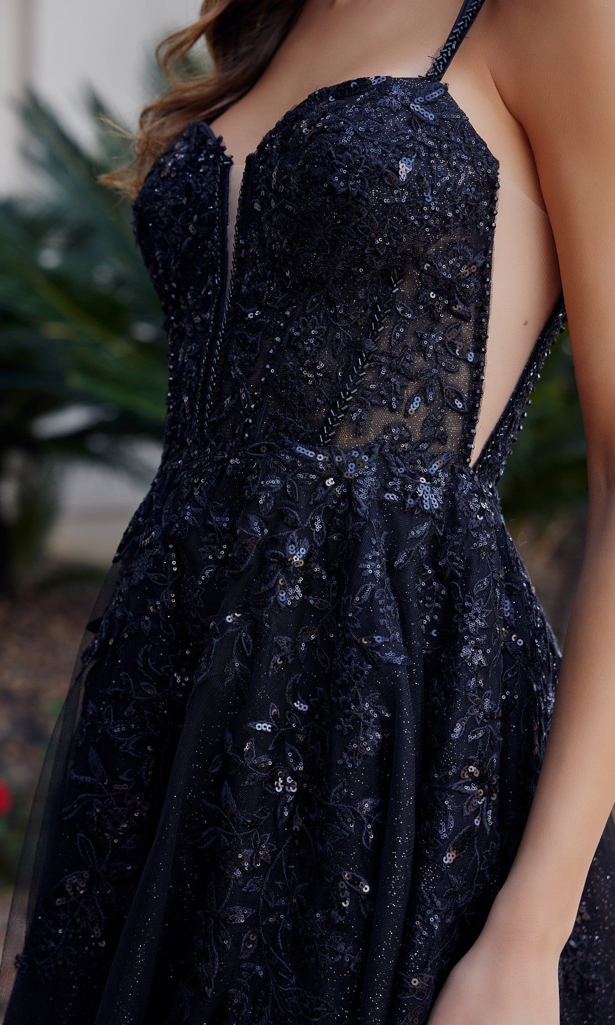 Close-up of a woman wearing the Nox Anabel H1885 long prom dress, featuring black sequins, lace details, and a sheer side panel.